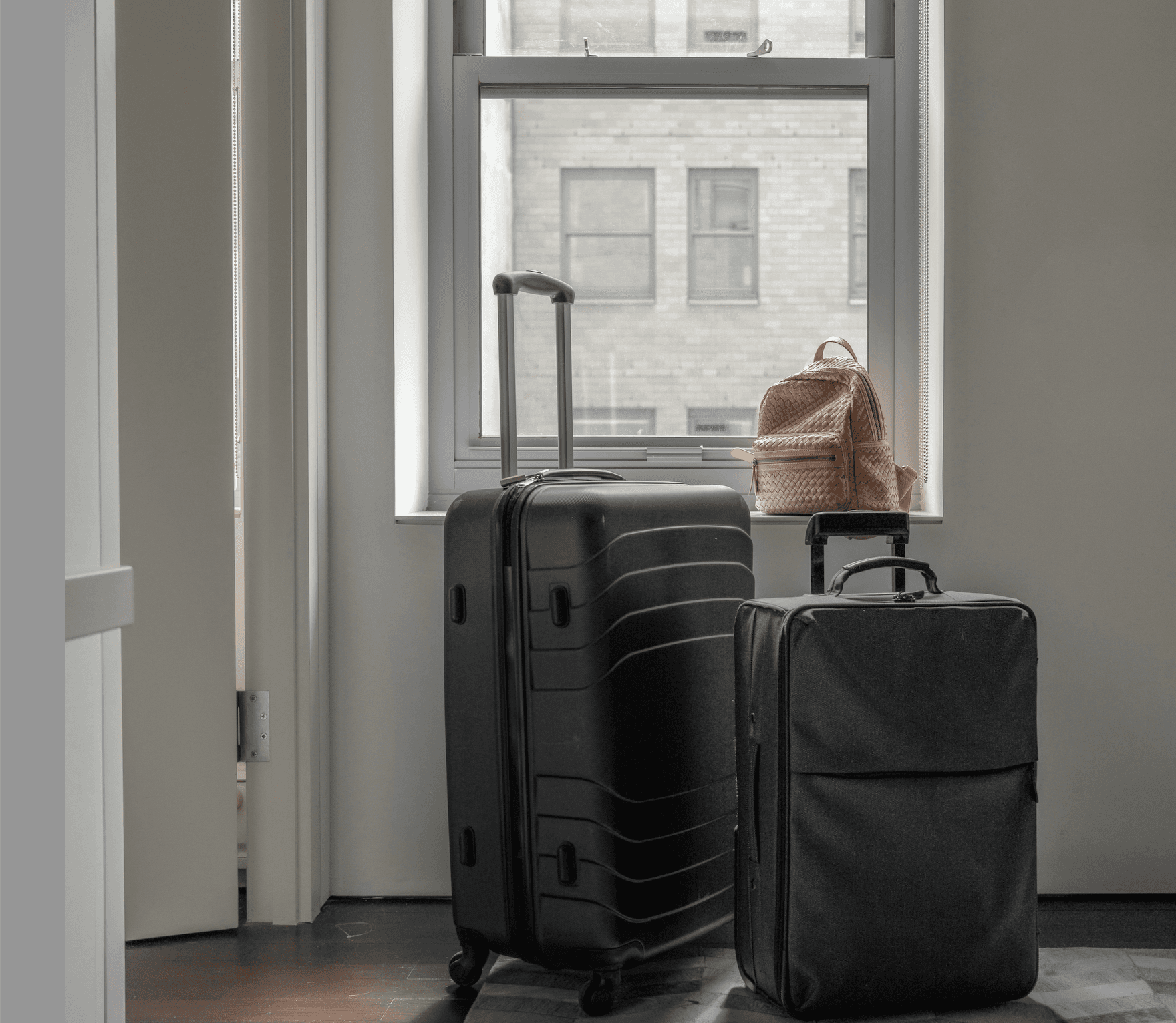 Suitcases in front of a window looking out on NYC buildings