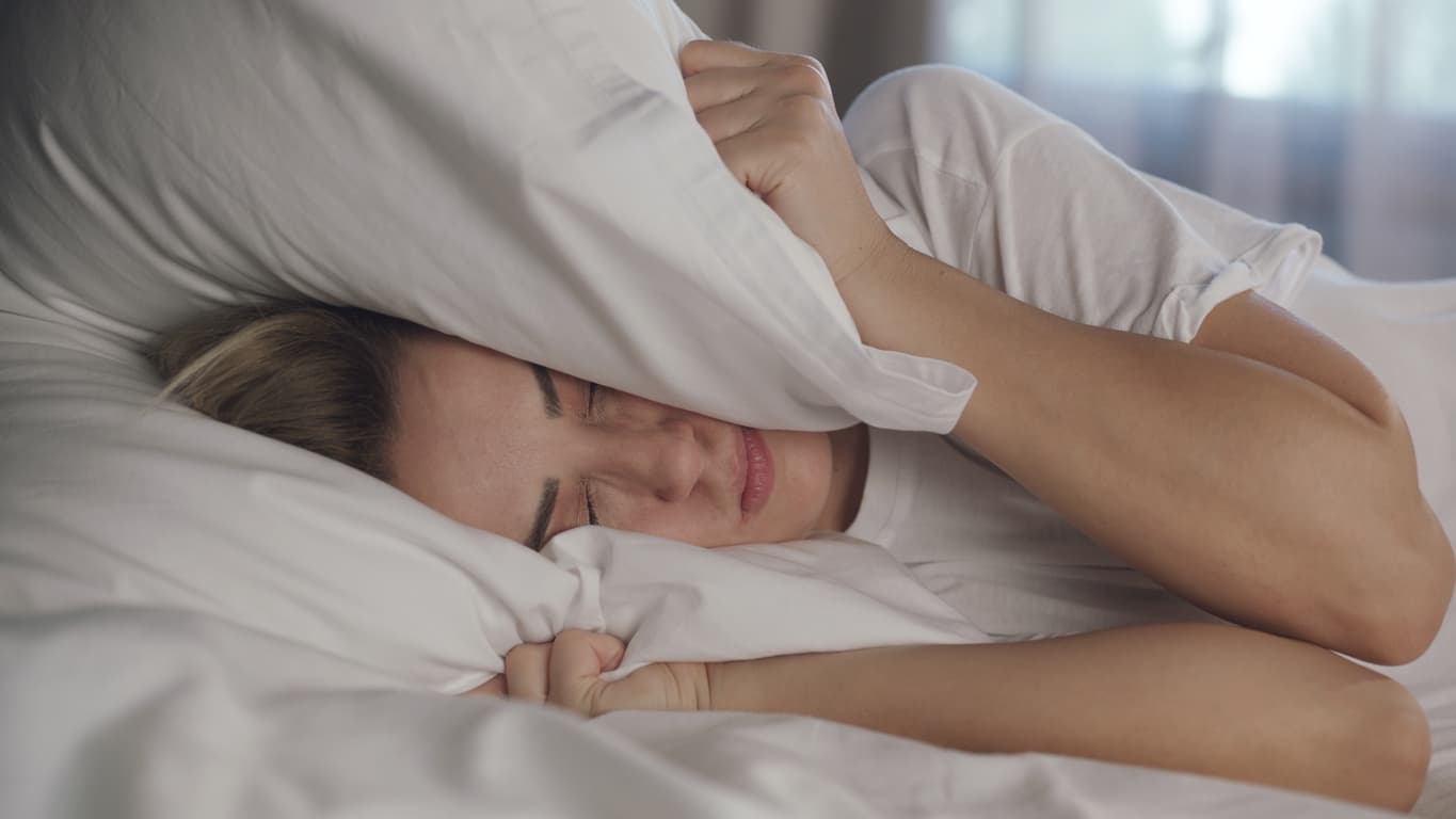 What can I do about a noisy upstairs neighbor who won't cover her floors?