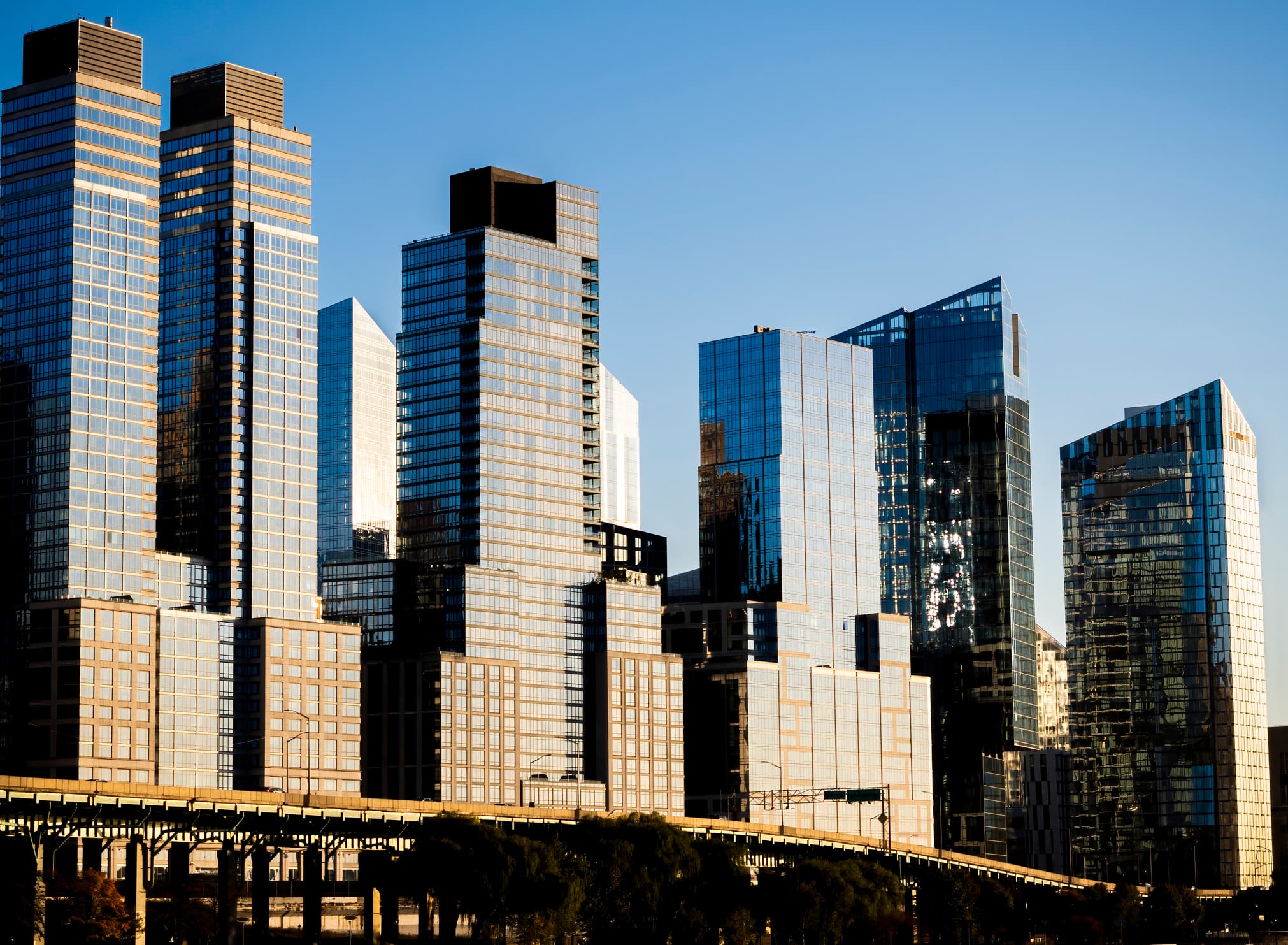 Glimmering steel and glass apartment buildings along the West Side Highway, south of the Henry Hudson Parkway, far west of Manhattan, New York City, on a sunny fall day. Skyline, NYC.