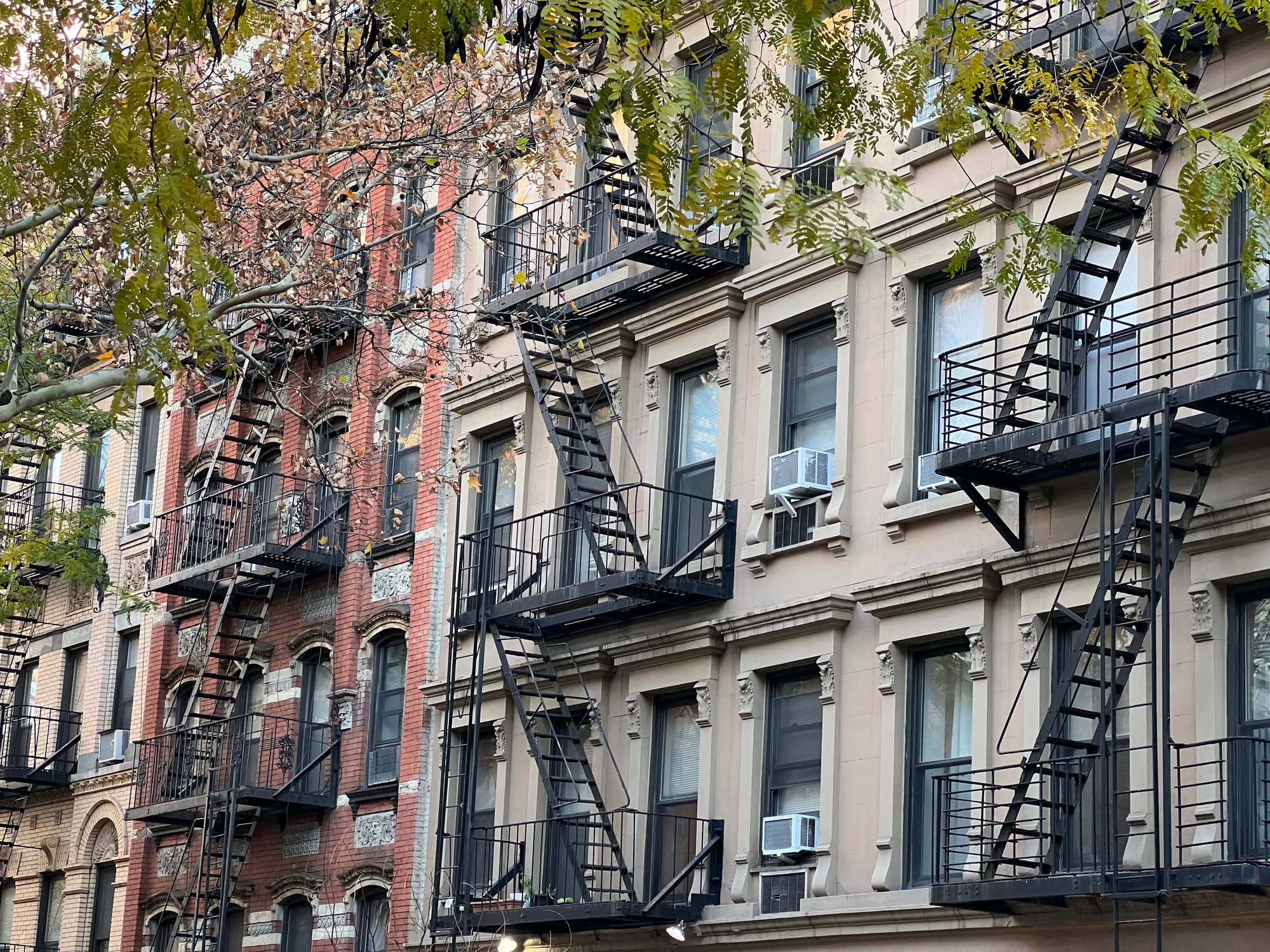 Old colorful buildings with fire ladder and trees on New-york manhattan, Upper East Side, buildings front house
