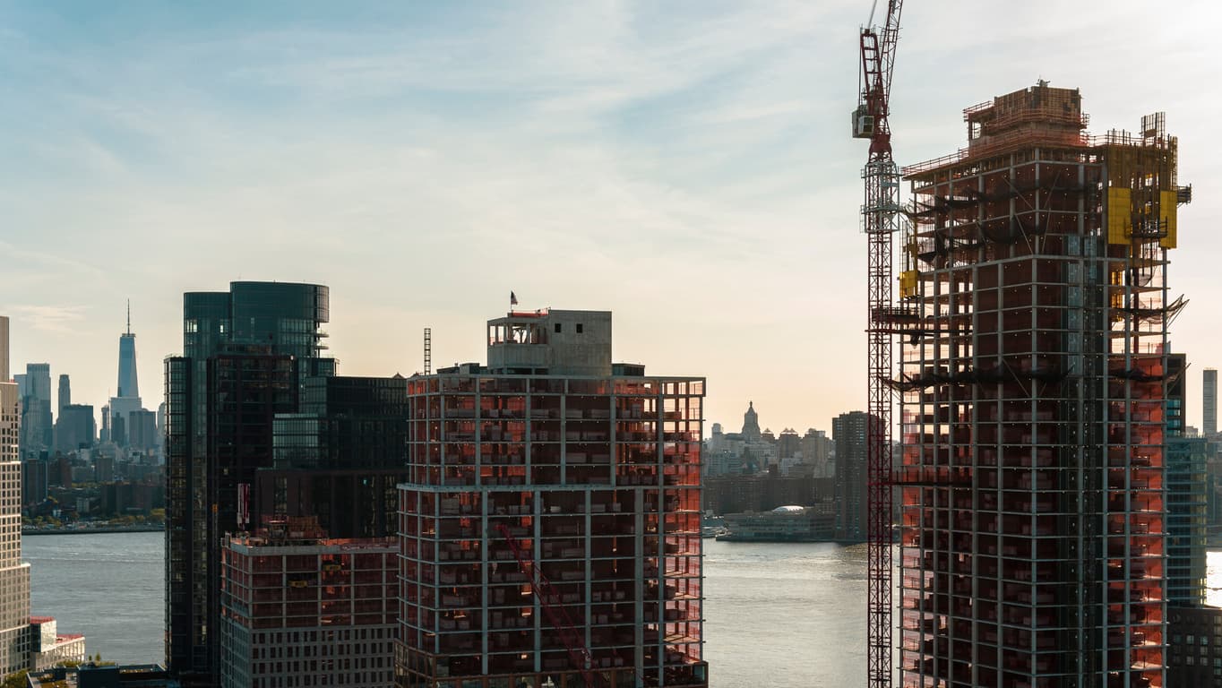 Modern buildings under construction on the waterfront in Greenpoint, Brooklyn with the view of Manhattan with Freedom Tower over the East River.