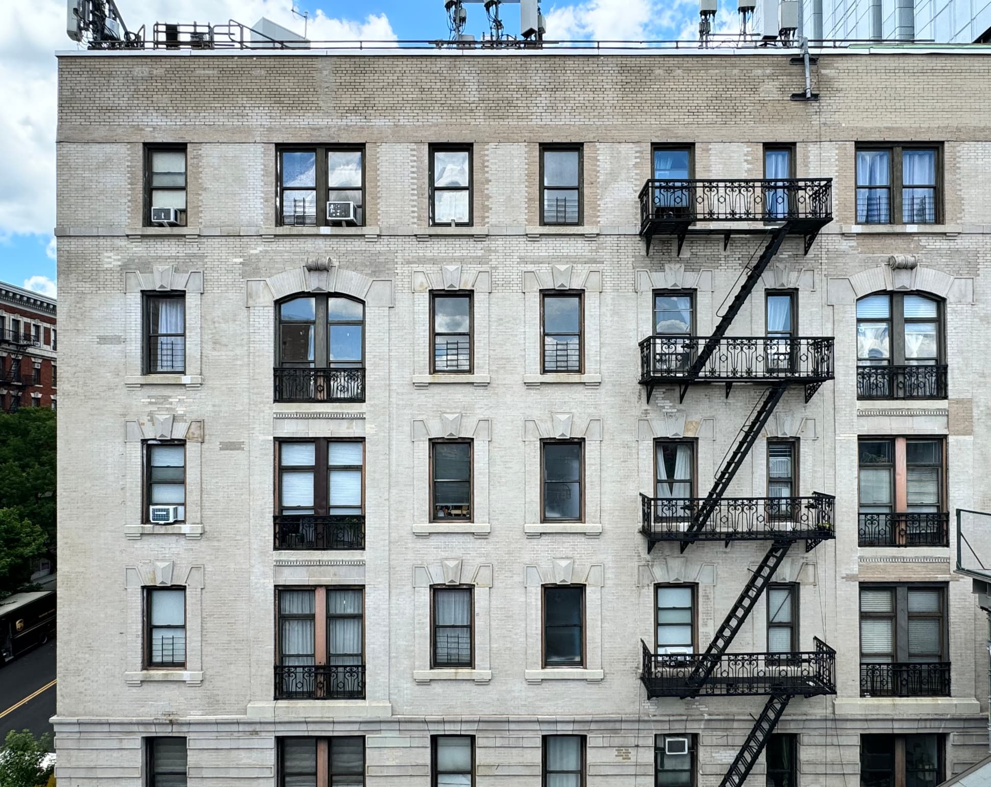 Front view of white pre-war apartment building facade seen from elevated subway station in Morningside Heights, Manhattan, New York City