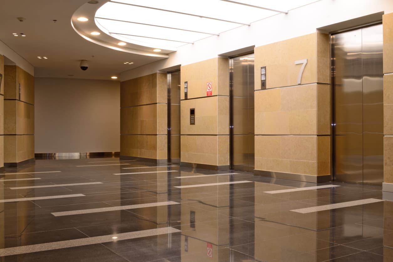 How does the number of elevators in a building affect property values?